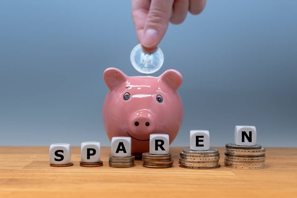 Os dados formam a palavra alemã "sparen" ("economizar dinheiro" em inglês) em
  - Foto, Imagem