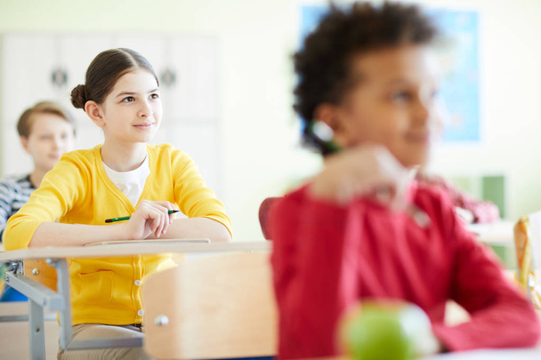 Meraklı okul öğrencileri masalarda oturan ve sınıfta öğretmen dinleme - Fotoğraf, Görsel
