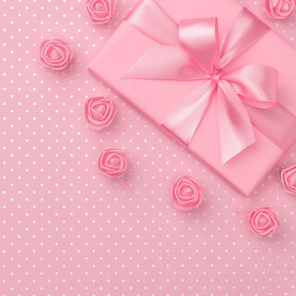 Άνοιξη διακόσμηση ροζ συσκευασία δώρου και ροδαλά λουλούδια επάνω προβολή για 8 Μαρτίου γυναικών μέρα αντίγραφο χώρου σε παστέλ ροζ χαρτί υπόβαθρο. Ημέρα μητέρας πρότυπο με το παρόν πλαίσιο. Επίπεδη θέσει. Συλλογή άνοιξη - Φωτογραφία, εικόνα