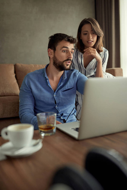 Man and woman enjoying time together browsing on laptop - Фото, изображение