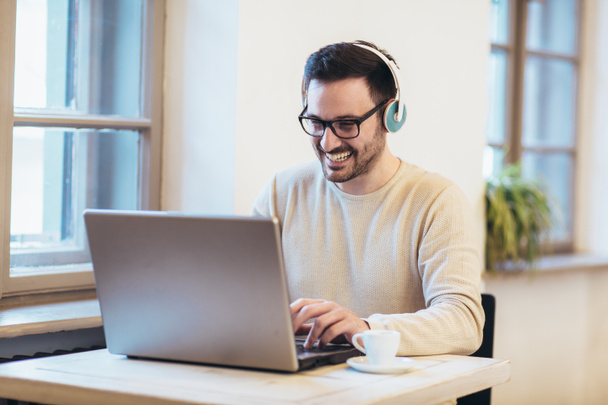 Man in front of laptop computer with headset - Photo, Image