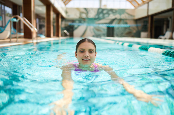 Giovane donna attiva nuotare in piscina da hotel di località termale durante le vacanze estive
 - Foto, immagini