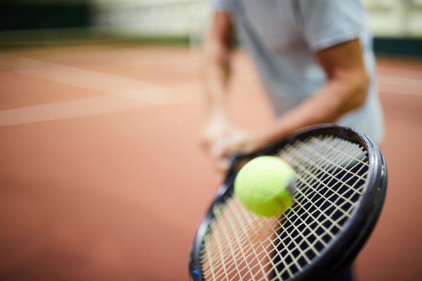 Κίνηση μπάλα του τένις να χτυπηθεί από ρακέτα στο χέρι του επαγγελματία παίκτη κατά τη διάρκεια του παιχνιδιού - Φωτογραφία, εικόνα