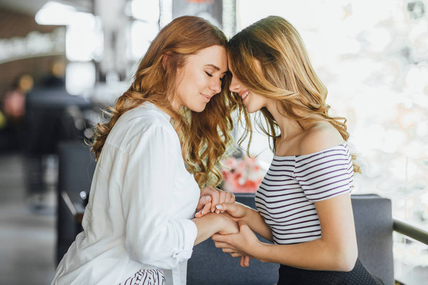 Mom and young daughter hugging on summer terrace in casual clothing, selective focus - Photo, Image