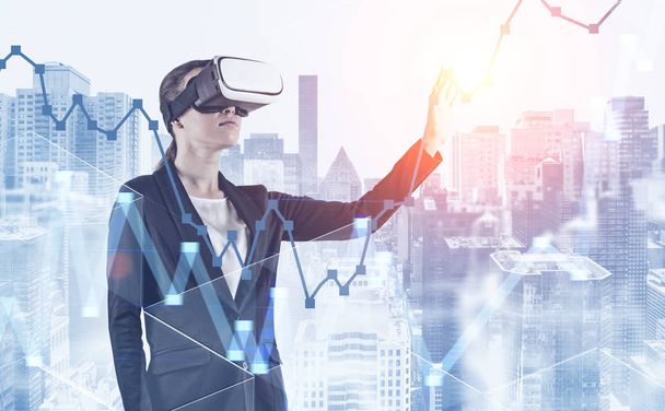 Woman in VR glasses working with graph in city - Photo, image