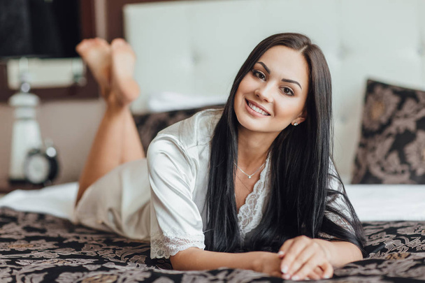 brunette woman lying on stomach in morning in room - Photo, Image