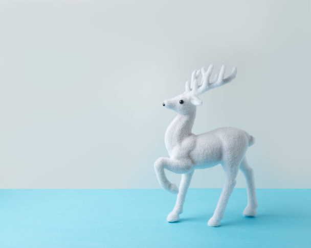 White reindeer on blue background. Christmas or New Year minimal concept. - Fotoğraf, Görsel