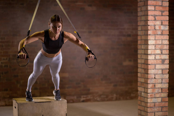 Fitness woman workout on TRX straps in gym. Crossfit style. Training TRX. - Fotografie, Obrázek