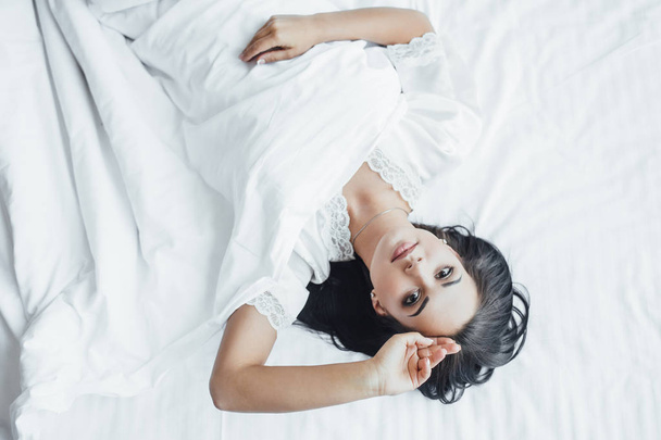 young beautiful woman lying in bed waking up in morning and sweating - Фото, зображення