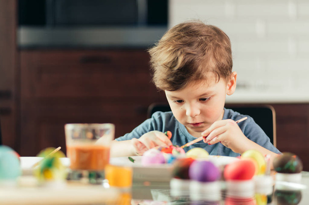 Happy little boy painting Easter eggs, children and creativity - Photo, Image
