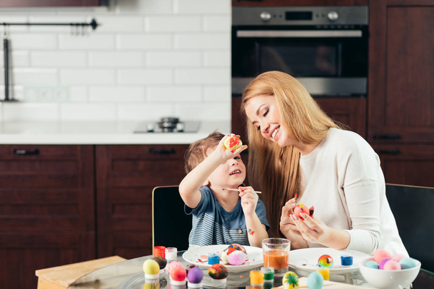 Happy Easter Young mother and her little son painting Easter eggs. - Фото, зображення
