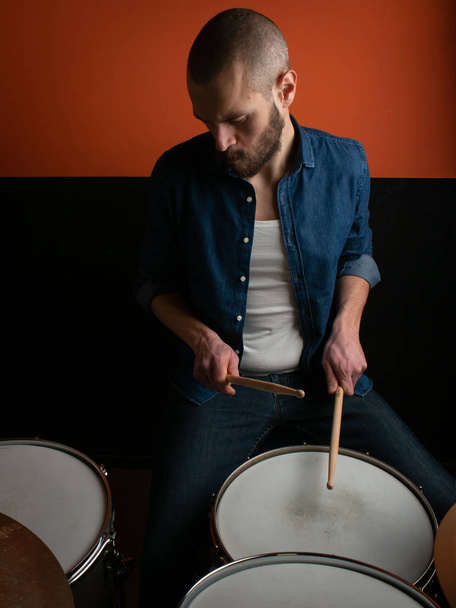 Garçon jouer du tambour avec chemise jeans et fond sombre
 - Photo, image