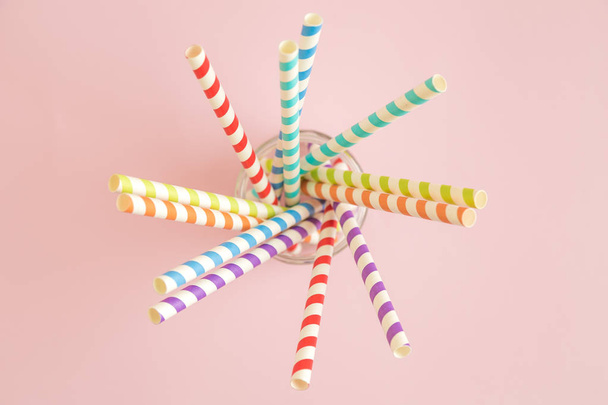 High angle view of paper straws in jar on rose background. - Foto, imagen