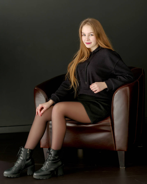 Fashionable girl teenager studio photo on a black background. - Fotó, kép