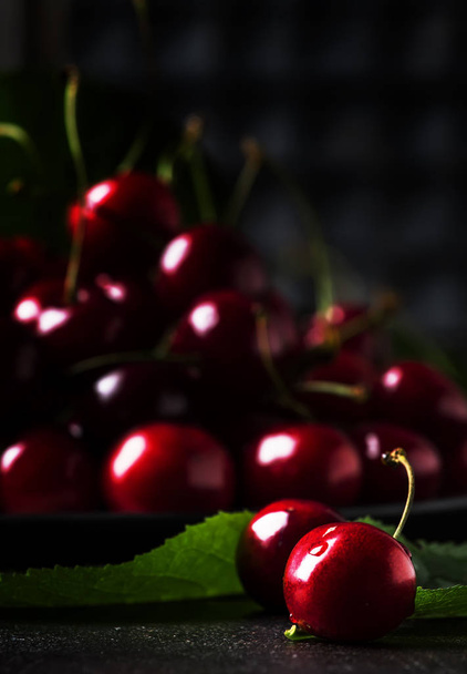 Red sweet cherries on brown kitchen table background, still life, selective focus - Photo, Image