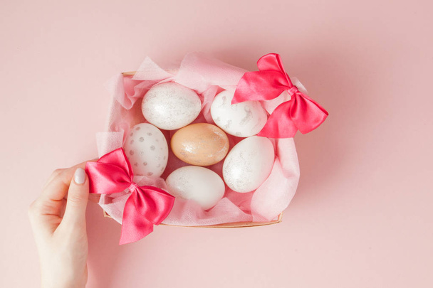 Wielkanoc biały jaja w gnieździe na różowym tle. Projekt pastelowych tonu w minimalnym lay płaskie - Zdjęcie, obraz
