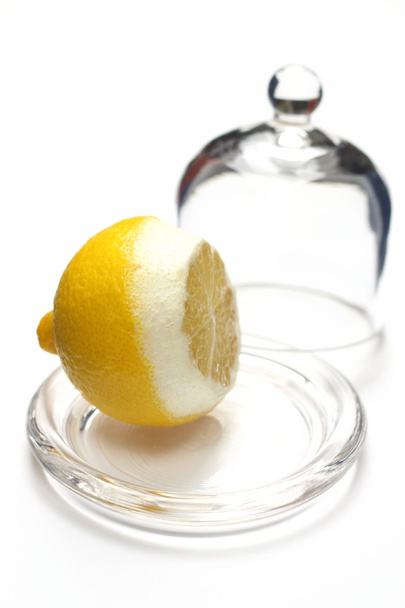 Лимон разрезан пополам под стеклянным покрытием
 - Фото, изображение