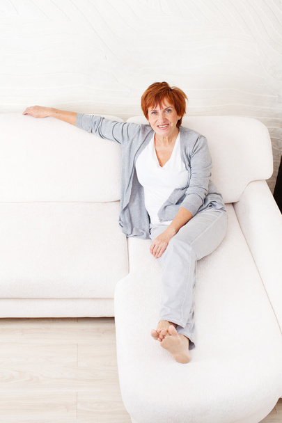 Щаслива зріла жінка на дивані
 - Фото, зображення