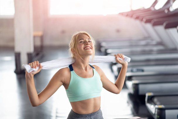 Mujer feliz quedarse con una toalla después del entrenamiento en el gimnasio, Fitne
 - Foto, Imagen