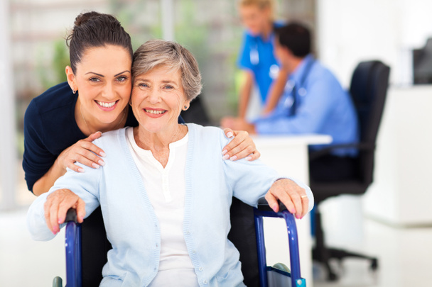 Erwachsene Tochter begleitet Seniorin beim Arztbesuch - Foto, Bild