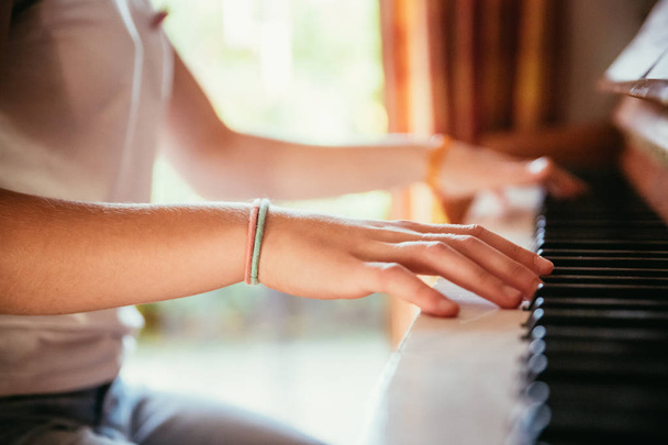 Girl is playing piano at home, high angle view, blurry backgroun - Foto, Bild
