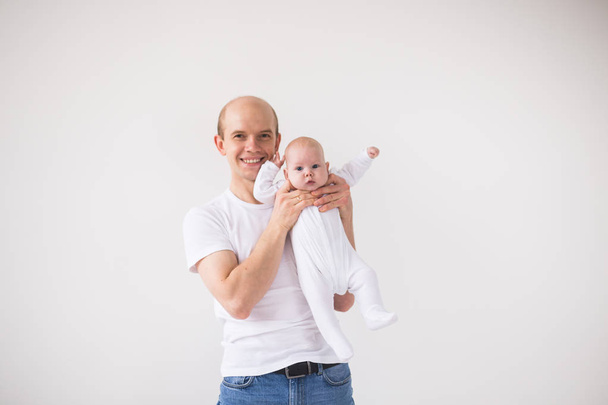 父権、親と赤ちゃんコンセプト - 幸せと笑顔はハゲ父娘少女白い背景の上に保持している男 - 写真・画像