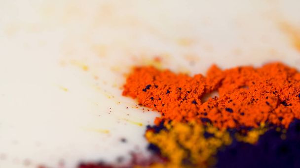 Powder ink on of milk. Close-up of powder colorful paint on surface of white liquid. Exotic vibrant spice powder on surface of liquid - Foto, Imagen