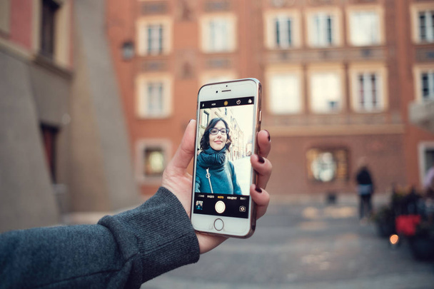 Zblízka pohled na ženské osoby drží mobil s a fotografie. Ženské ruce s mobilních telefonů vymyslet, prstem dotknete displeje - Fotografie, Obrázek