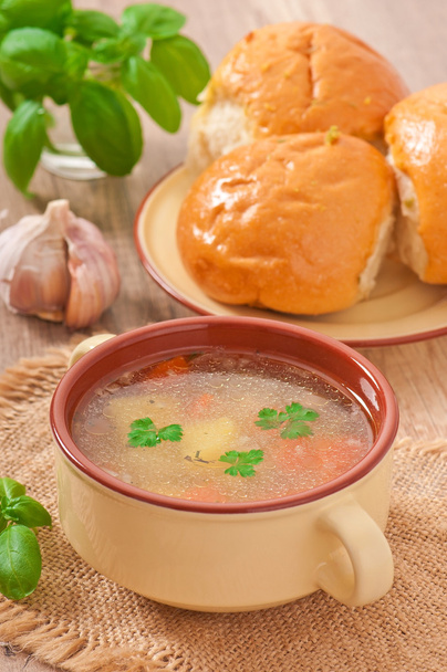 Курячий суп у коричневій керамічній мисці
 - Фото, зображення