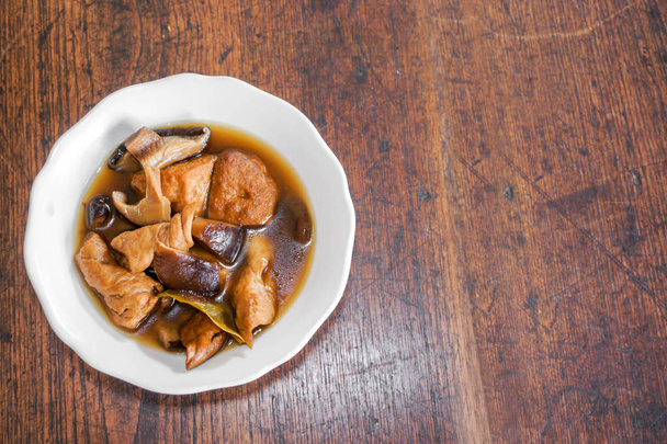 Felülnézet kínai vegetáriánus ételek "Tofu és száraz zöldséget, párolt a mártással" fehér kerámia tál és fából készült asztal másol hely szövegek háttér. - Fotó, kép
