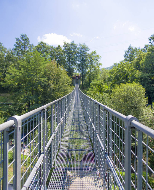 suspension bridge over the valley and the wooded mountains - Photo, Image