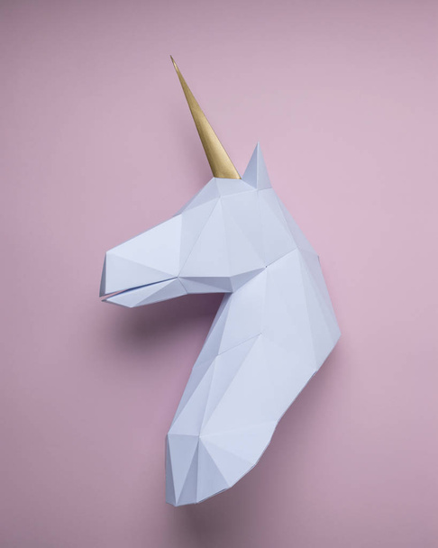White 3d papercraft model of unicorn head on pink background. Minimal art concept. - Foto, afbeelding