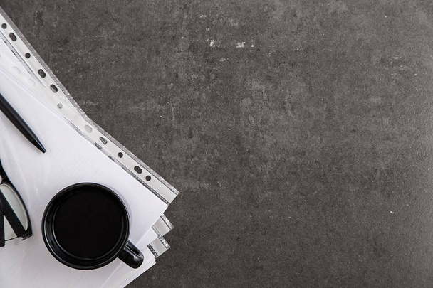 Black cup of coffee and black pen on documents on grey marble background. Top view - Fotografie, Obrázek