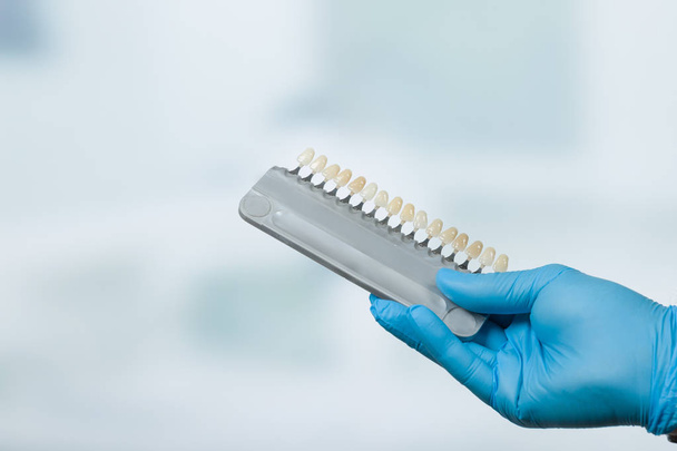 Dentysta ręka z cieniu przewodnik aby sprawdzić okleina korony zęba w laboratorium dentystyczne - Zdjęcie, obraz