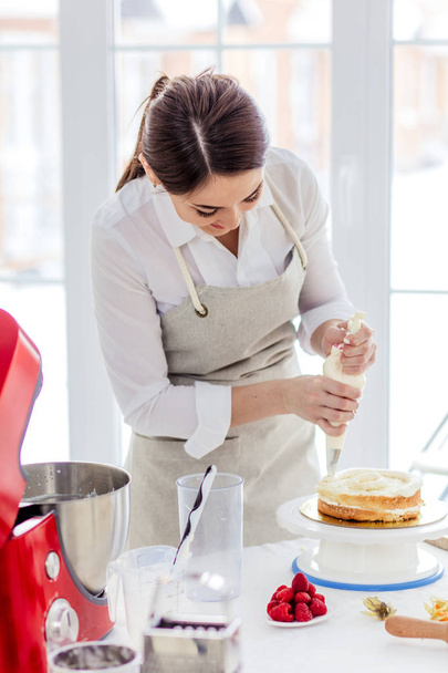 positive female chef decorating cake - Zdjęcie, obraz