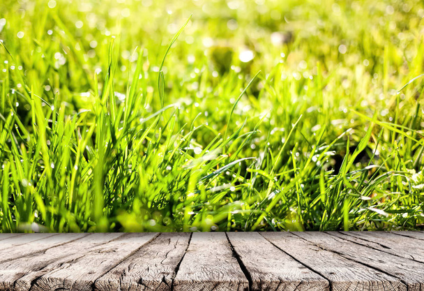 Wooden table top and spring grass nature background - Photo, Image