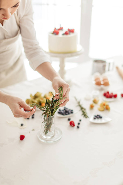 housewife using gorgeous greenery while preparing cake - Foto, immagini