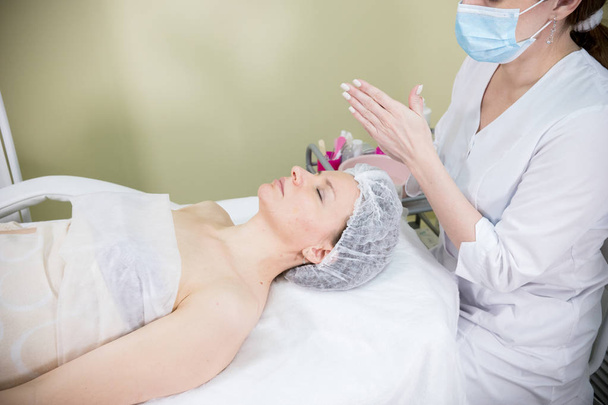 Il cosmetologo prepara la faccia di clienti a procedura cosmetica di mesotherapy
 - Foto, immagini