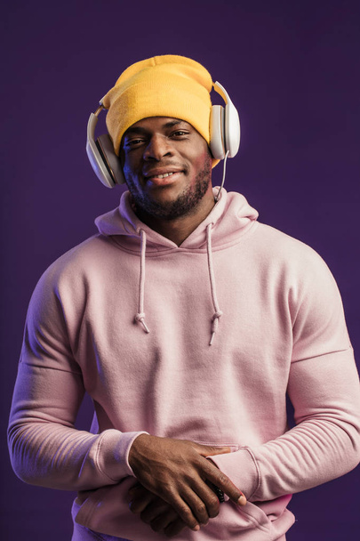 African man in hoodie with headphones isolated, happy expression. Music, people - Foto, Imagem
