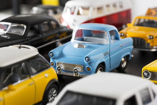 Stacked toy cars and a 50s model blue toy car in the focus. - Foto, afbeelding