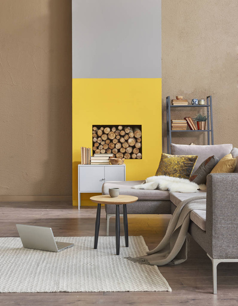 soggiorno moderno con camino, divano, laptop e dettagli gialli
 - Foto, immagini
