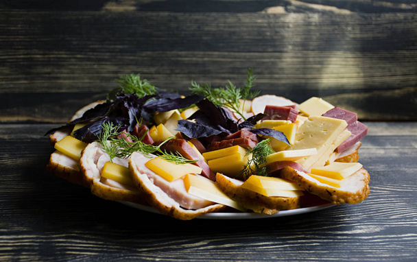Salami, sliced ham and cheese salad and vegetables. Squeezing sausage and cured meat on a festive table. - Fotografie, Obrázek