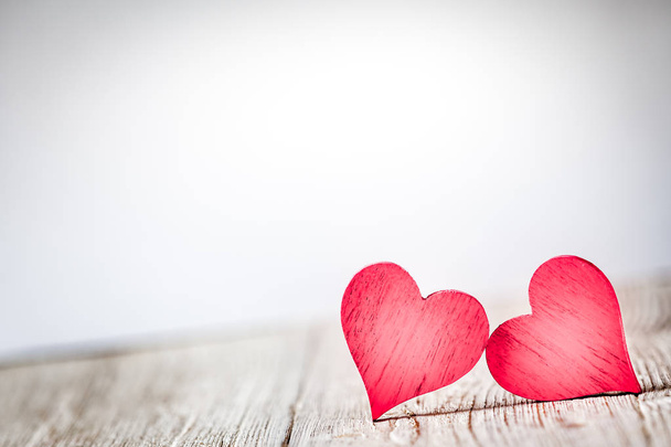 Two red hearts on wooden background - 写真・画像