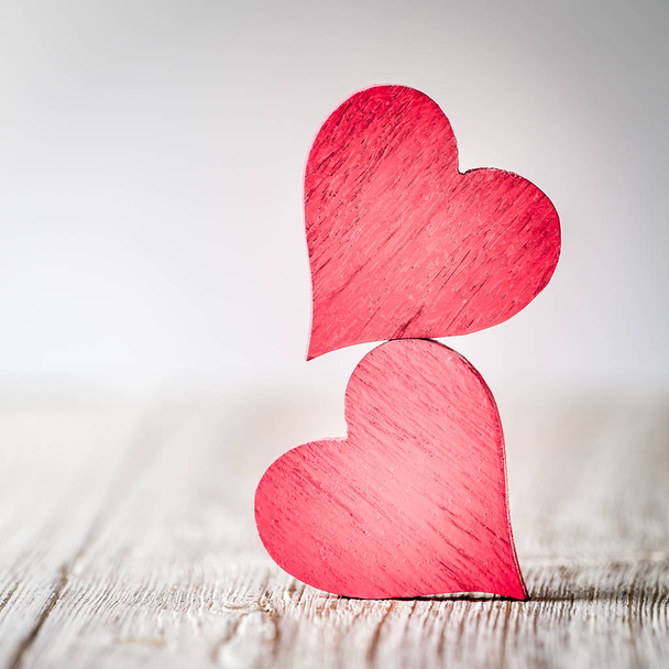 Two red hearts on wooden background - Foto, imagen