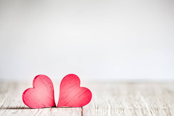 Two red hearts on wooden background - Фото, изображение
