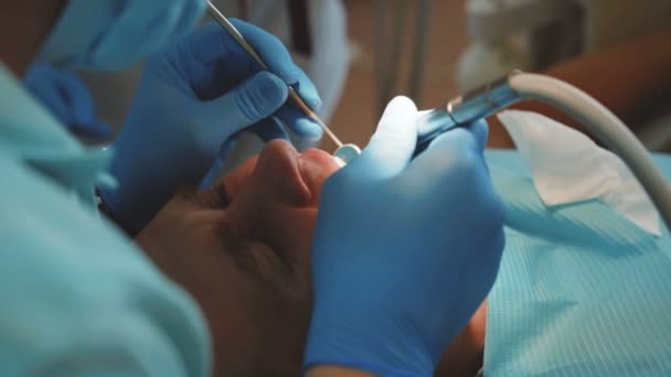Dentist treats patients teeth with dental drill in clinic. 4K - Кадры, видео