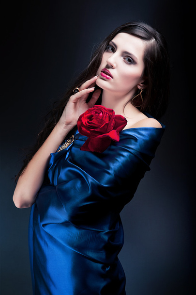 woman in blue fabric with red rose - Foto, Bild