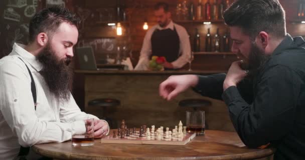 zwei Freunde mit stylischen Bärten beim Schachspiel in einer Kneipe - Filmmaterial, Video