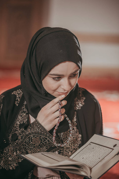 Young muslim girl reading a holy book  - Photo, image