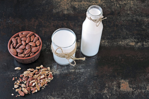 Almond milk in a glass and bottle. Fresh raw almonds. Nut milk. - Photo, Image